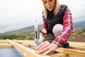 Femme qui scelle une toiture à Laval - Réparation toiture urgence (toiture à Laval)